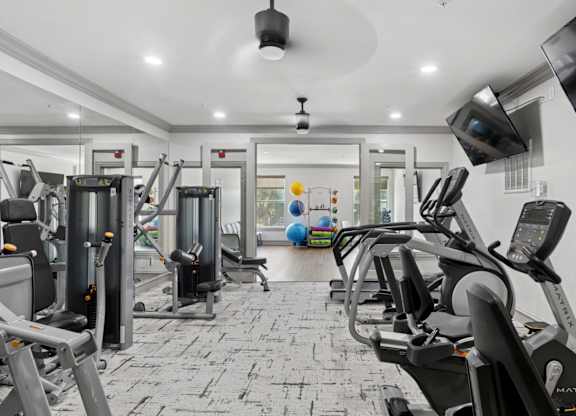 A fitness center with yoga balls and strength training equipment at Encore at Buckingham Apartments in Richardson, TX