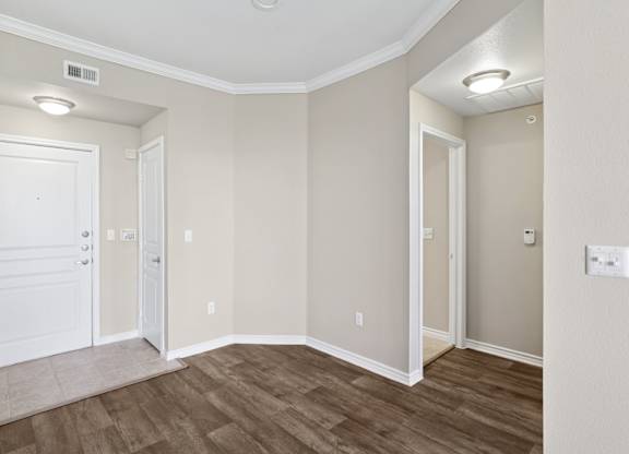 Kenzington dining room with a white door and a wooden floor at Encore at Buckingham Apartments in Richardson, TX