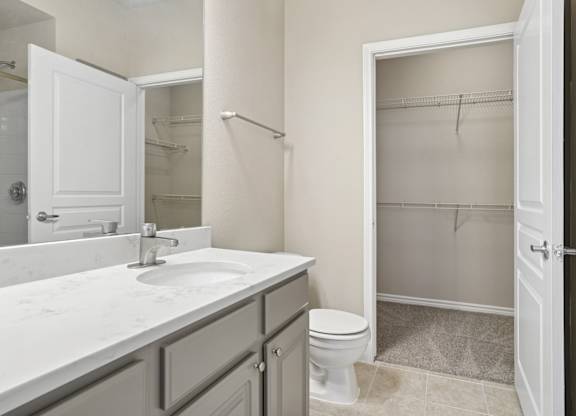 Kenzington bathroom with a white sink and toilet at Encore at Buckingham Apartments in Richardson, TX