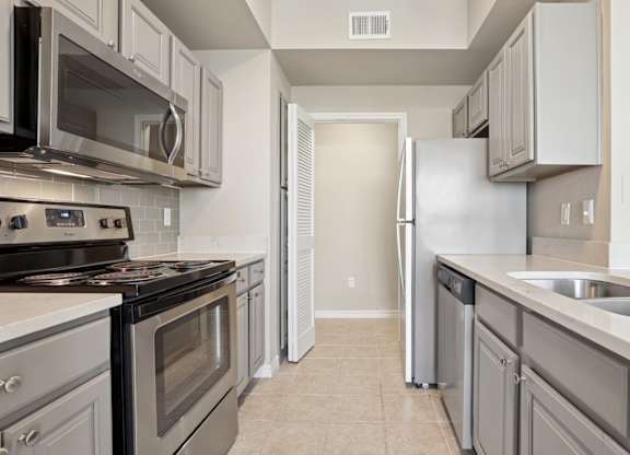 Kenzington kitchen with stainless steel appliances at Encore at Buckingham Apartments in Richardson, TX