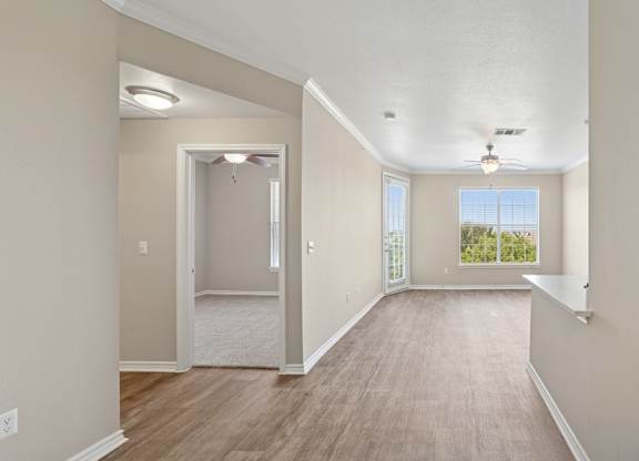 Kenzington living room with a carpeted floor and a ceiling fan at Encore at Buckingham Apartments in Richardson, TX