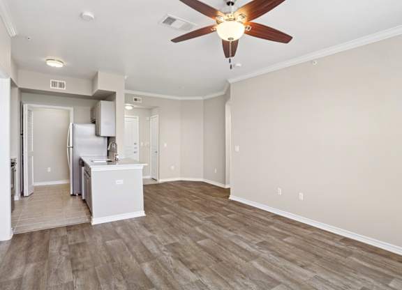 Kenzington living room with wood floors and a ceiling fan at Encore at Buckingham Apartments in Richardson, TX