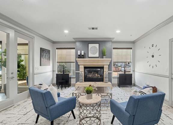 A leasing office with a fireplace and chairs at Encore at Buckingham Apartments in Richardson, TX