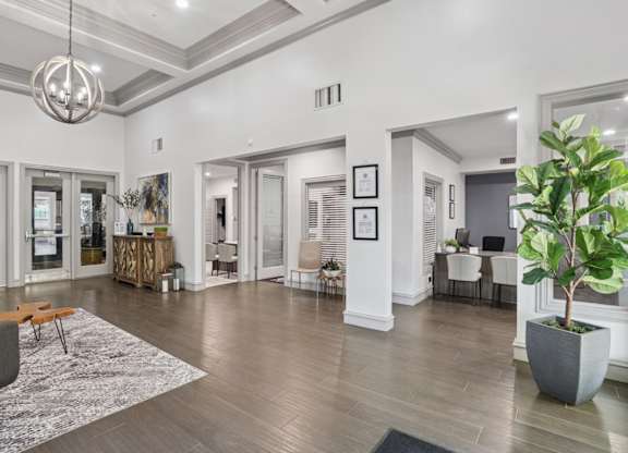 A leasing office with a grey sofa and a large rug at Encore at Buckingham Apartments in Richardson, TX