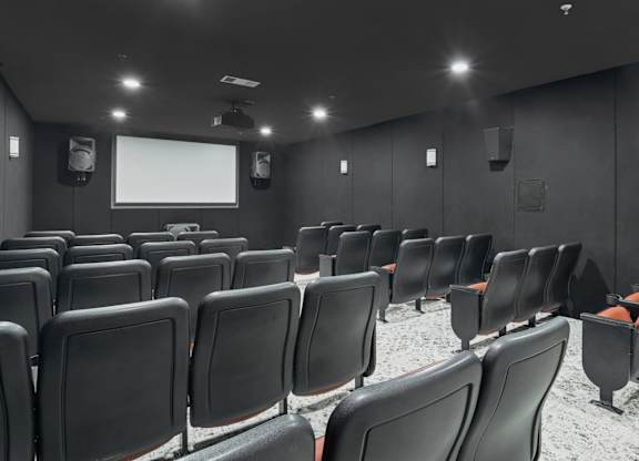 A movie theater with dark walls and speakers at Encore at Buckingham Apartments in Richardson, TX