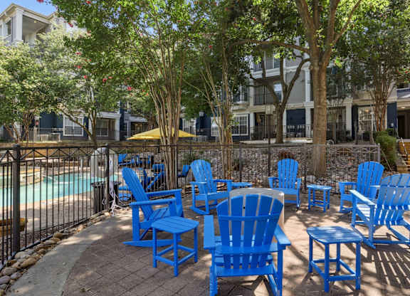 Outdoor seating near the pool at Encore at Buckingham Apartments in Richardson, TX