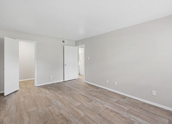 A room with wood flooring and white walls.
