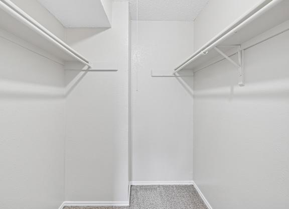 A white closet with a grey carpet.