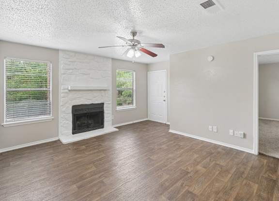 A room with a fireplace and a ceiling fan.