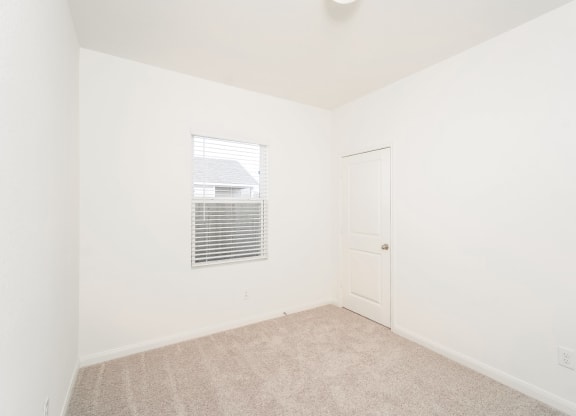 a bedroom with white walls and carpet