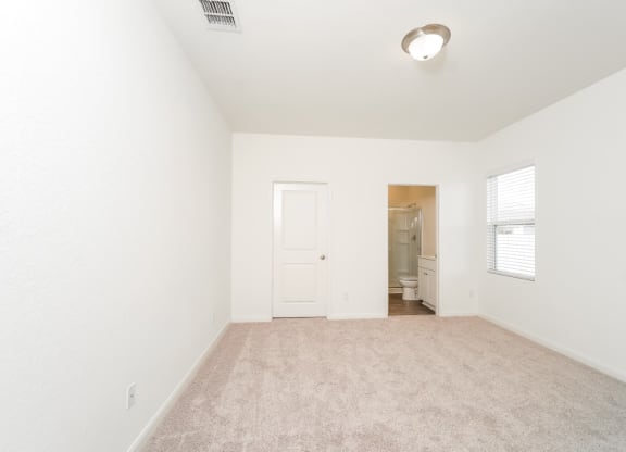 a bedroom with white walls and carpet