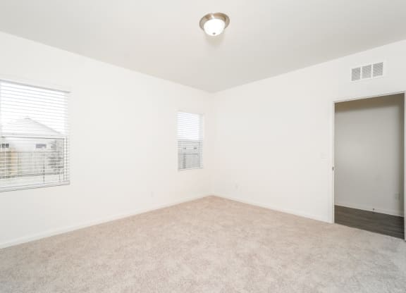 a bedroom with white walls and carpet