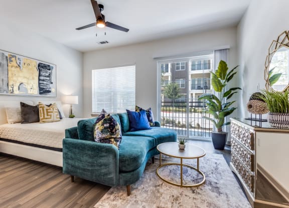 Model Studio apartment living room with a bed and a couch at Era Apartments in Denton, TX