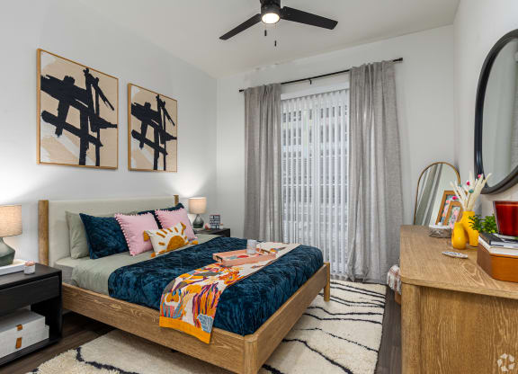Model apartment spacious bedroom with ceiling fan at Era apartments in Denton, TX