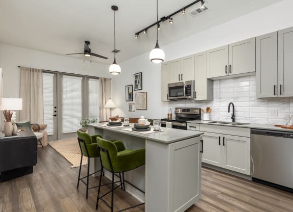 Model apartment open-concept kitchen and living room quartz countertops at Era apartments in Denton, TX