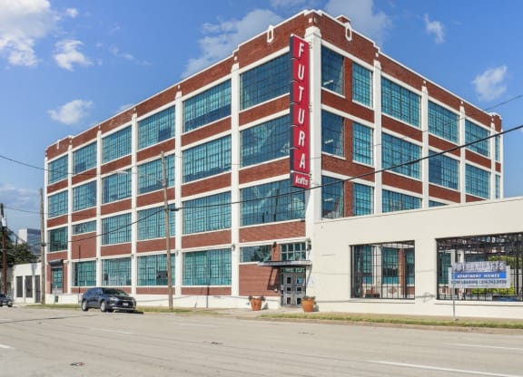 a large brick building with a red sign on the side of it