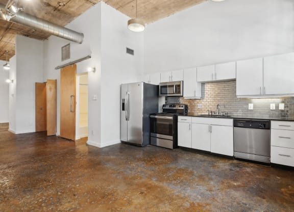 a kitchen with white cabinets and a stainless steel refrigerator