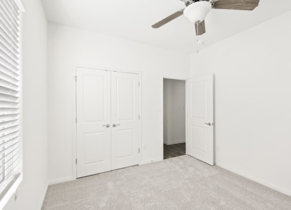 a bedroom with one closet and a ceiling fan