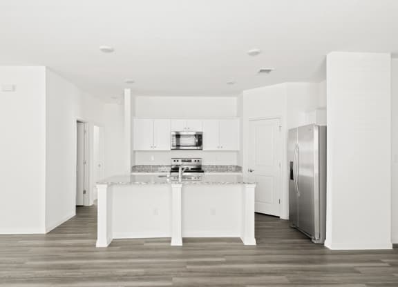 a kitchen with white cabinets and modern appliances