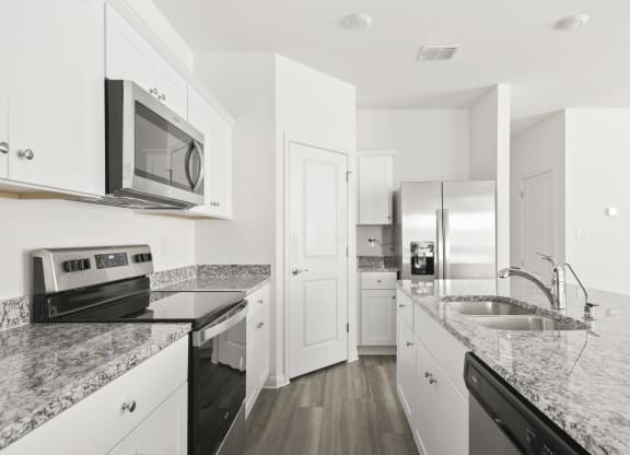 a kitchen with white cabinets and stainless steel appliances