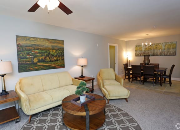 Model apartment living room and dining room with a couch and a dining table at Grand Reserve at Pelham in Pelham, AL