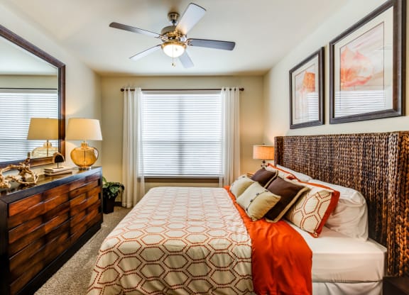 a bedroom with a large bed and a ceiling fan