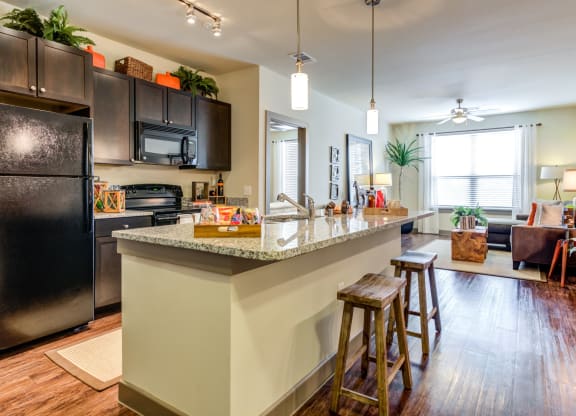 an open kitchen with a large island with bar stools