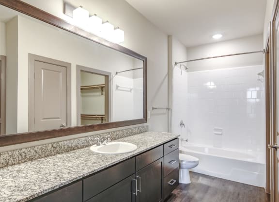 a bathroom with a large mirror and a white sink