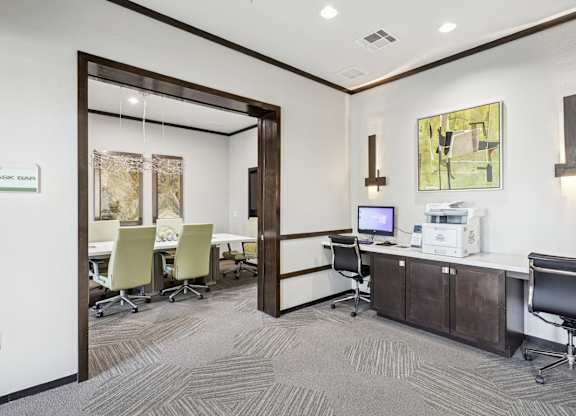 A business center with a computer, printer, and conference room at GreenVue Apartments in Richardson, TX