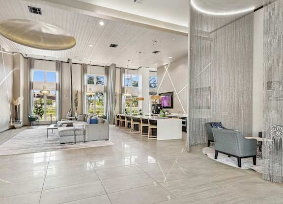 Spacious clubhouse with large windows, televisions, and couches at GreenVue Apartments in Richardson, TX