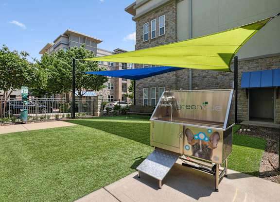Bark park with shaded area and a pet wash station at GreenVue apartments in Richardson, TX