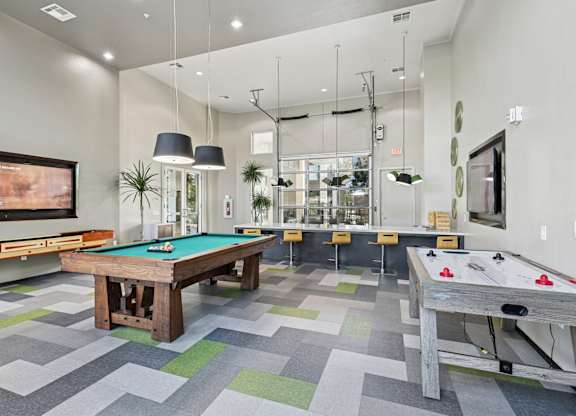 Game room with pool table and air hockey at GreenVue apartments in Richardson, TX