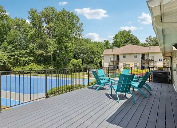 A deck with a table and chairs overlooking a basketball court at Gwinnett Square Apartments in Duluth, GA