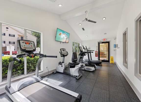 A fitness center with treadmills and ellipticals at Gwinnett Square Apartments in Duluth, GA