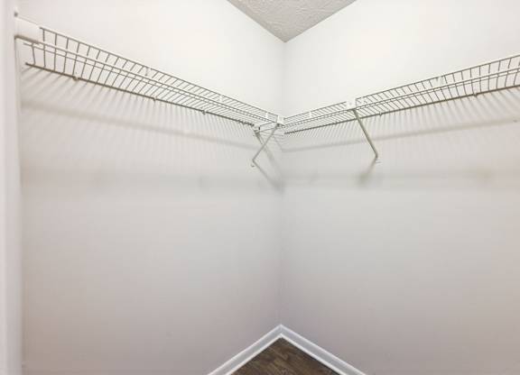 A closets with shelves and clothes rods at Gwinnett Square Apartments in Duluth, GA