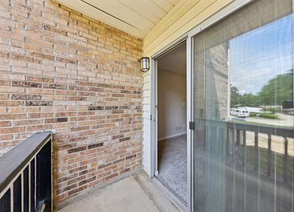 A balcony with a glass door at Gwinnett Square Apartments in Duluth, GA