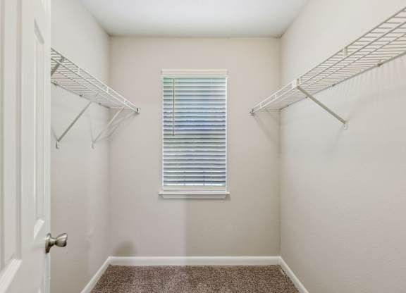A white closet with a window and a carpeted floor at Gwinnett Square Apartments in Duluth, GA