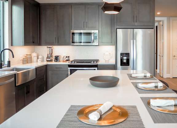 3 bedroom model kitchen with a white quartz counter top and a stainless steel appliances at The Hamilton apartments in Dallas, TX