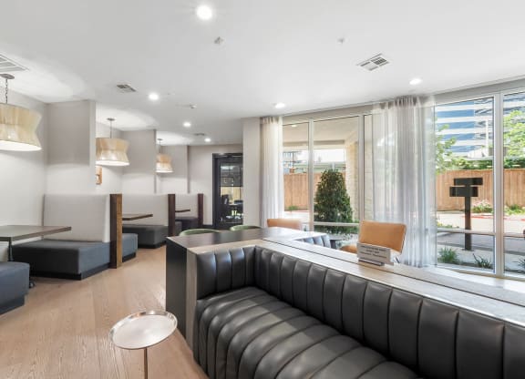 a room with couches and tables in front of a large window