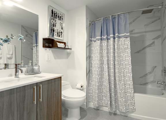 Modern bathroom with a toilet, sink, and shower in our model 2 bedroom apartment at Hollywood Heights on the Boulevard Luxury Apartments in Hollywood, FL