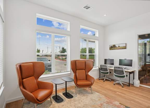 A business center with computers and chairs at Hillside on Parmer Lane Apartments in Austin, TX