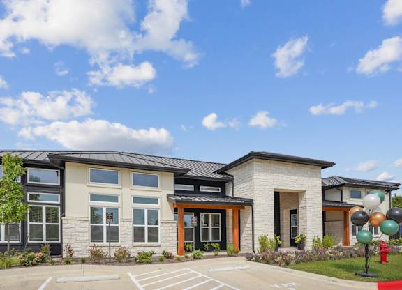 The exterior of a leasing office with parking in front at Hillside on Parmer Lane Apartments in Austin, TX