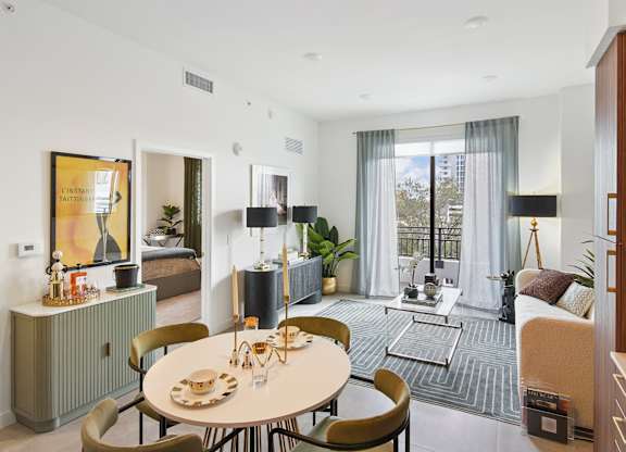 A modern dining room with a round table and chairs at Hollywood Heights on the Boulevard Luxury Apartments in Hollywood, FL