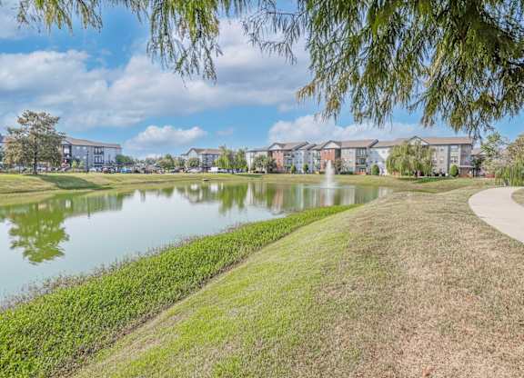Onsite pond with apartment buildings in the background at Ultris Island Park in Shreveport, LA