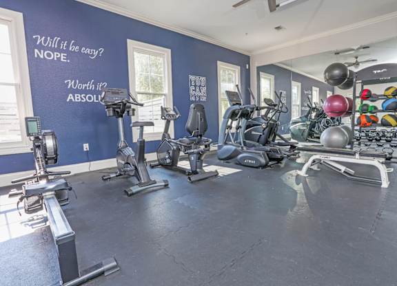 A gym with a variety of equipment and motivational quotes on the wall at Ultris Island Park in Shreveport, LA