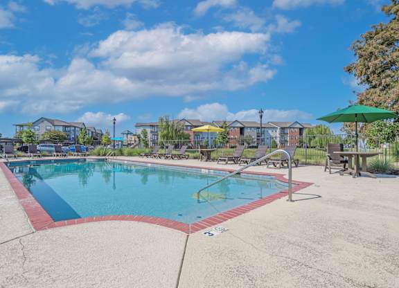 Pool area with seating and umbrellas at Ultris Island Park in Shreveport, LA