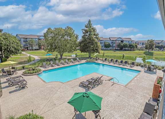 Aerial view of our pool with poolside lounge chairs and an umbrella table at Ultris Island Park in Shreveport, LA
