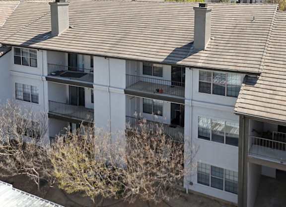 Apartment building with brown shingled roofs and balconies at Jefferson Place Apartments in Irving, TX