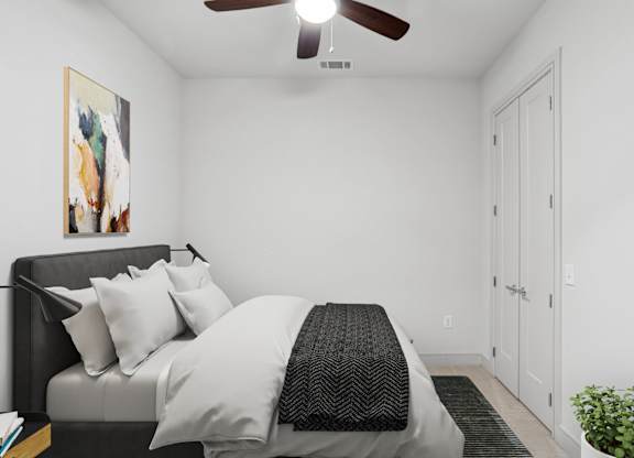 A virtually staged bedroom with a bed, a ceiling fan, and a painting on the wall at Knox Heights apartments in Dallas, TX