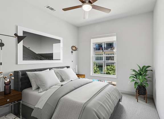 A virtually staged bedroom with a large bed and a ceiling fan at Knox Heights apartments in Dallas, TX